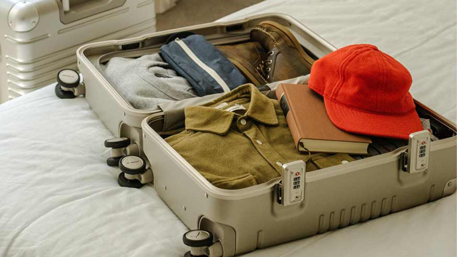 arlo skye the frame carry on suitcase on bed opened up with clothes packed