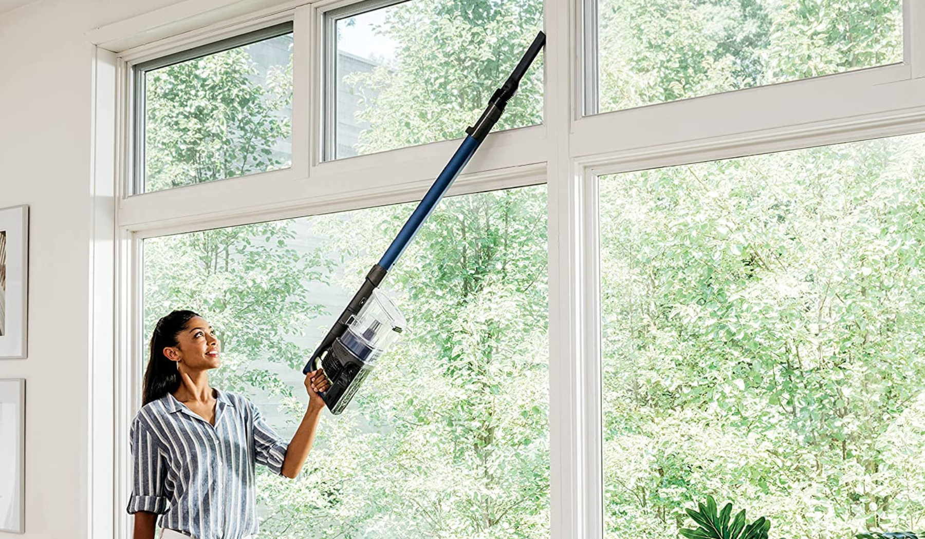 Person using Shark cordless vacuum to clean windows