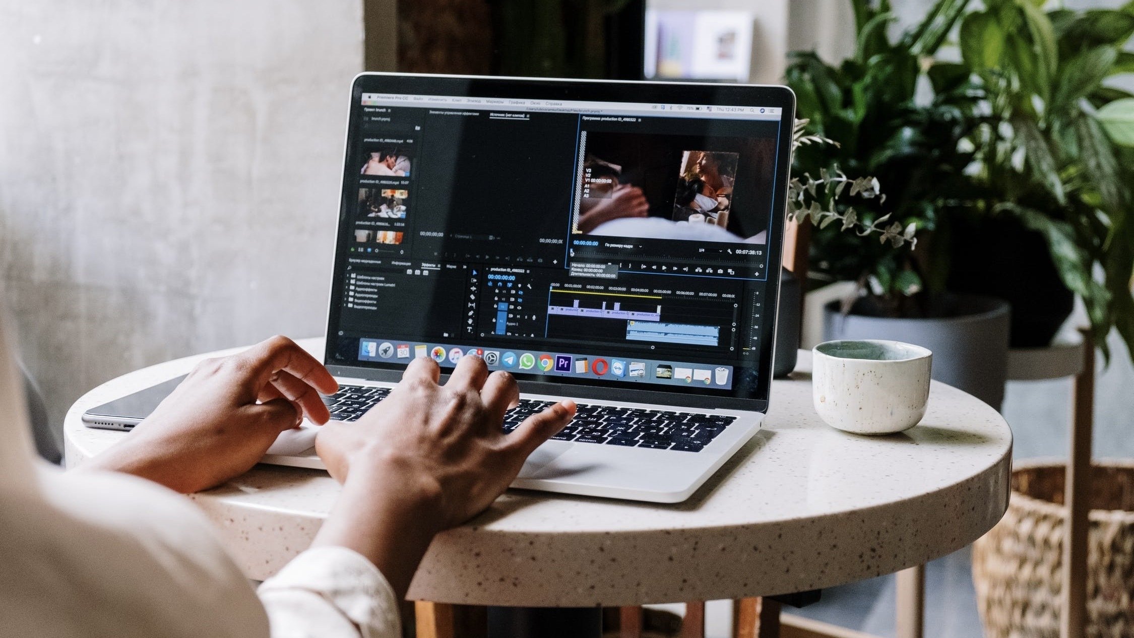Person working on Adobe programs on laptop.