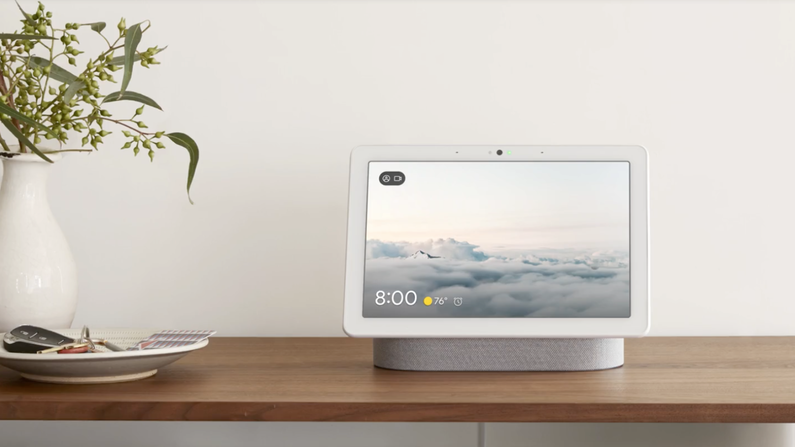 google nest hub max in white sitting on table with plant