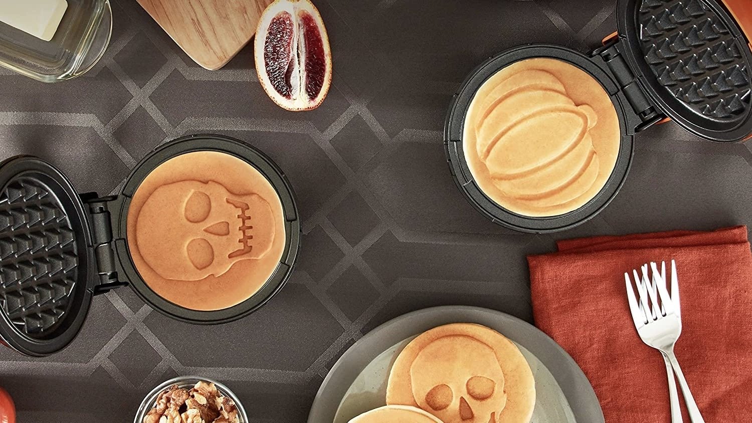halloween dash waffle makers with skull and pumpkin waffles on a black and orange table setting