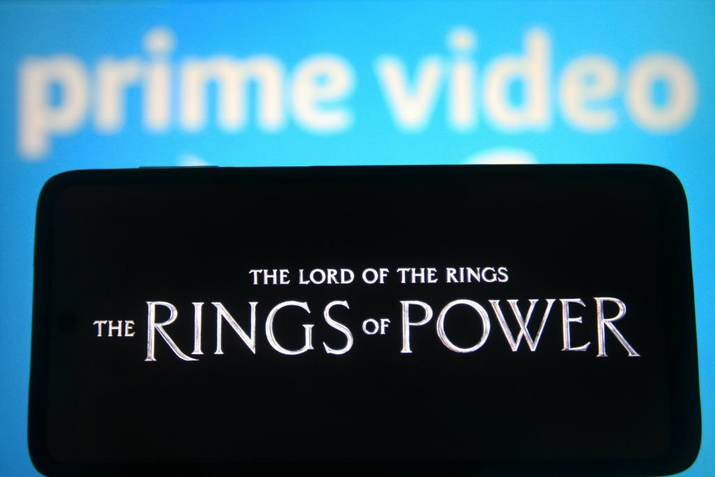 a phone with the rings of power in front of Prime Video background