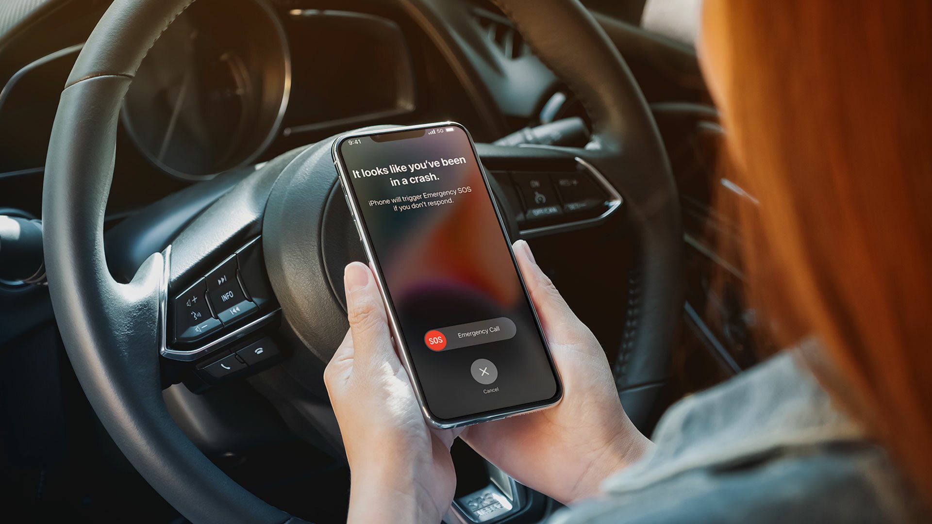 A woman looking at iPhone 14 crash detection in the driver's of a car