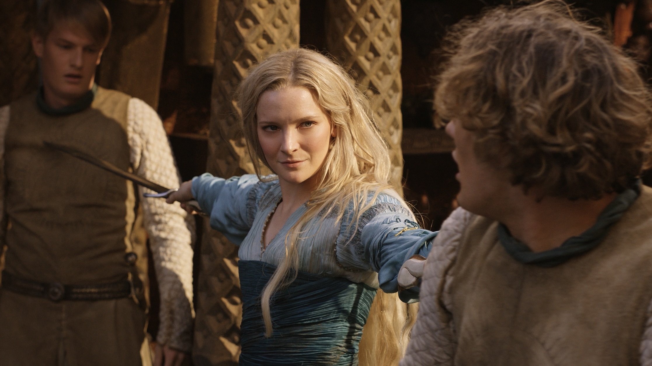 An elf woman in a blue dress holds two attackers at bay with two swords.