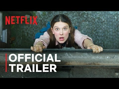 Enola Holmes hanging off a balcony while staring in the camera