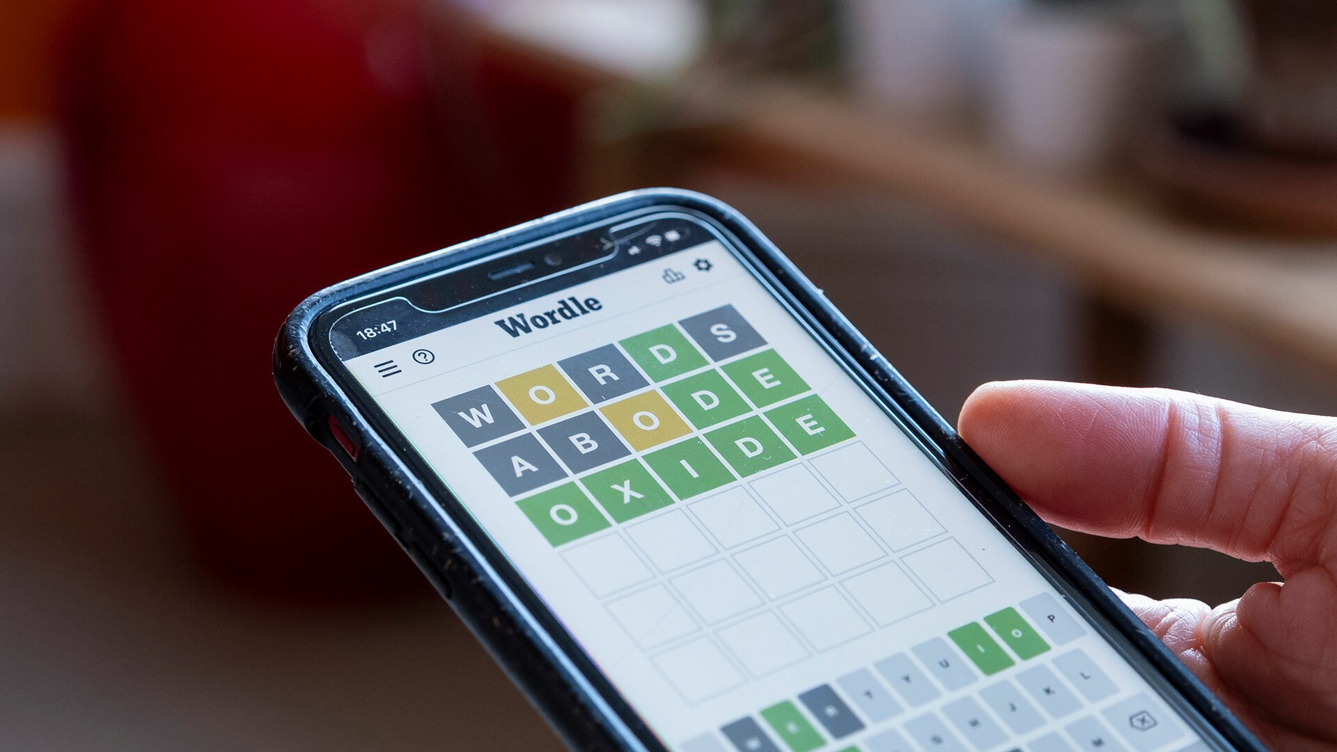A close-up of a person playing Wordle on their smartphone.