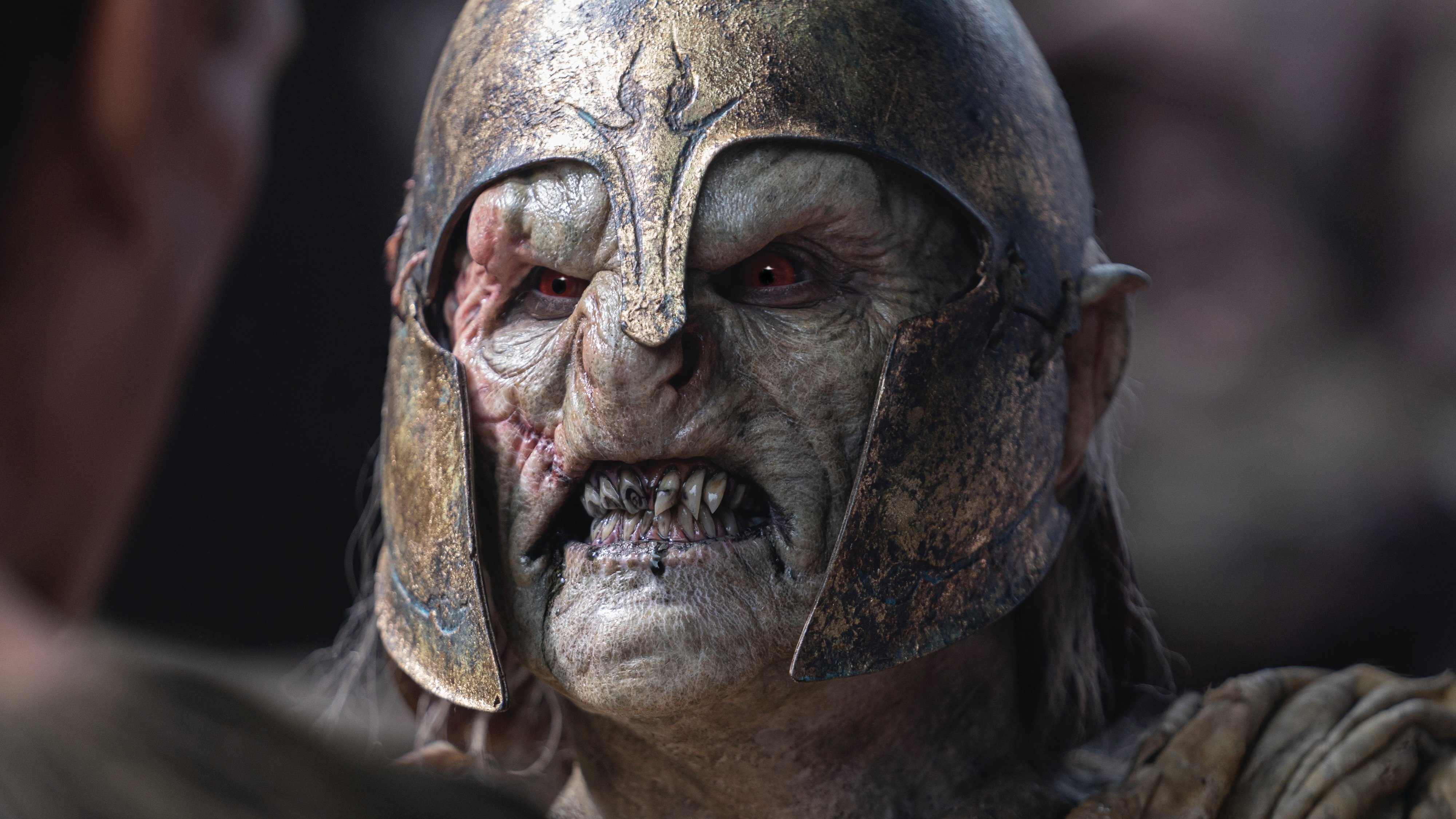A pale, snarling orc in a helmet.