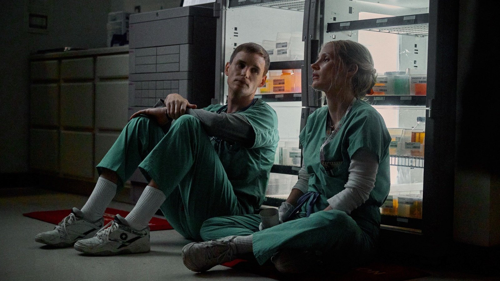 Jessica Chastain and Eddie Redmayne sit on a hospital floor in