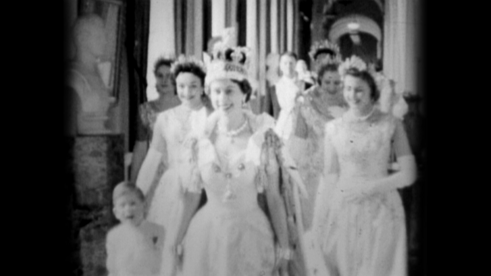 In this handout photo provided by Clarence House, Queen Elizabeth II walks down the Principal Corridor with Prince Charles (L) on the day of her Coronation on June 02, 1953 in London, England.