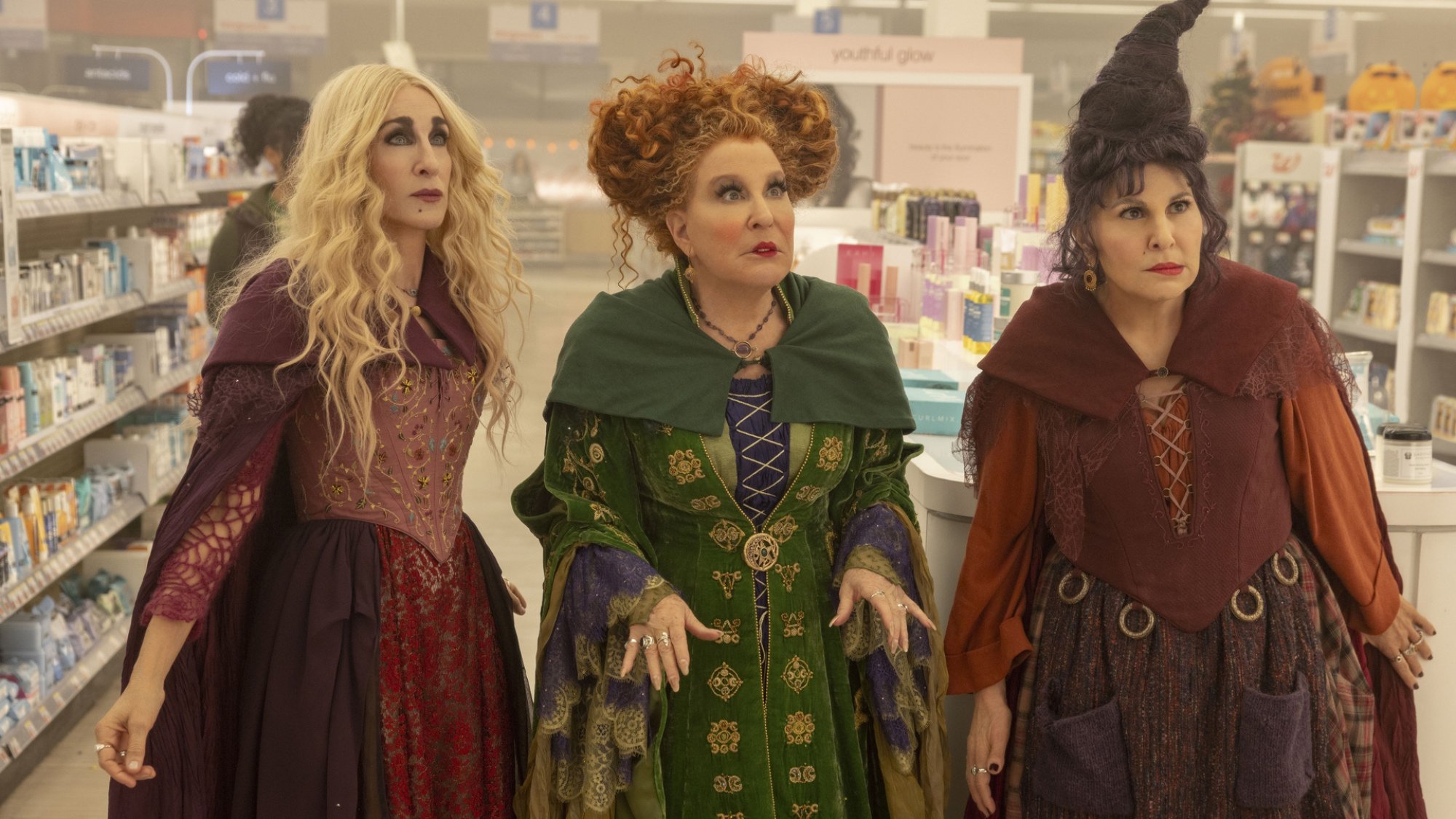 Three witches stand in a Walgreens, looking confused.