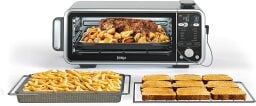 Ninja Foodi oven with food inside and two trays of food outside