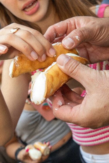 Crowd eating Cannolis