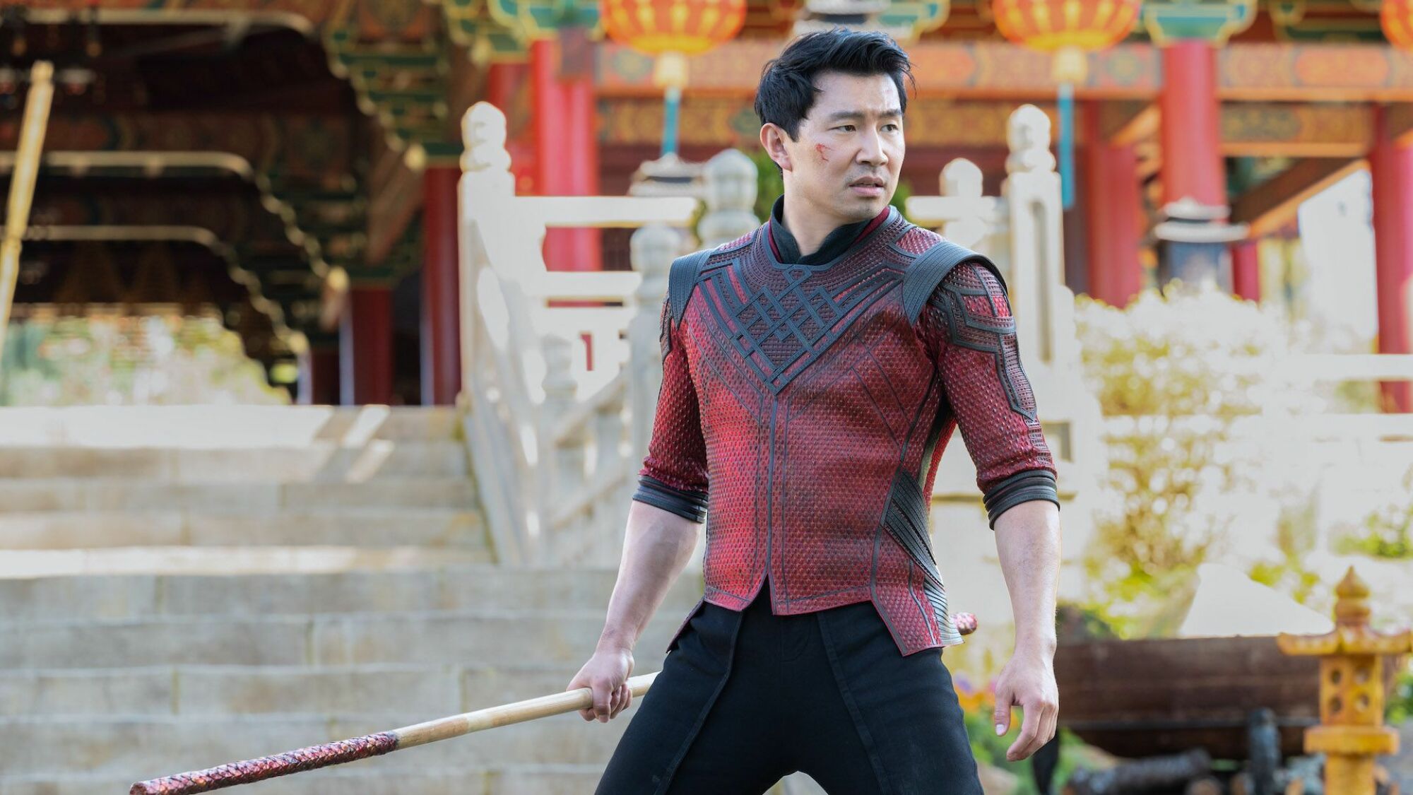 A man in armor stands outside a temple ready to fight.