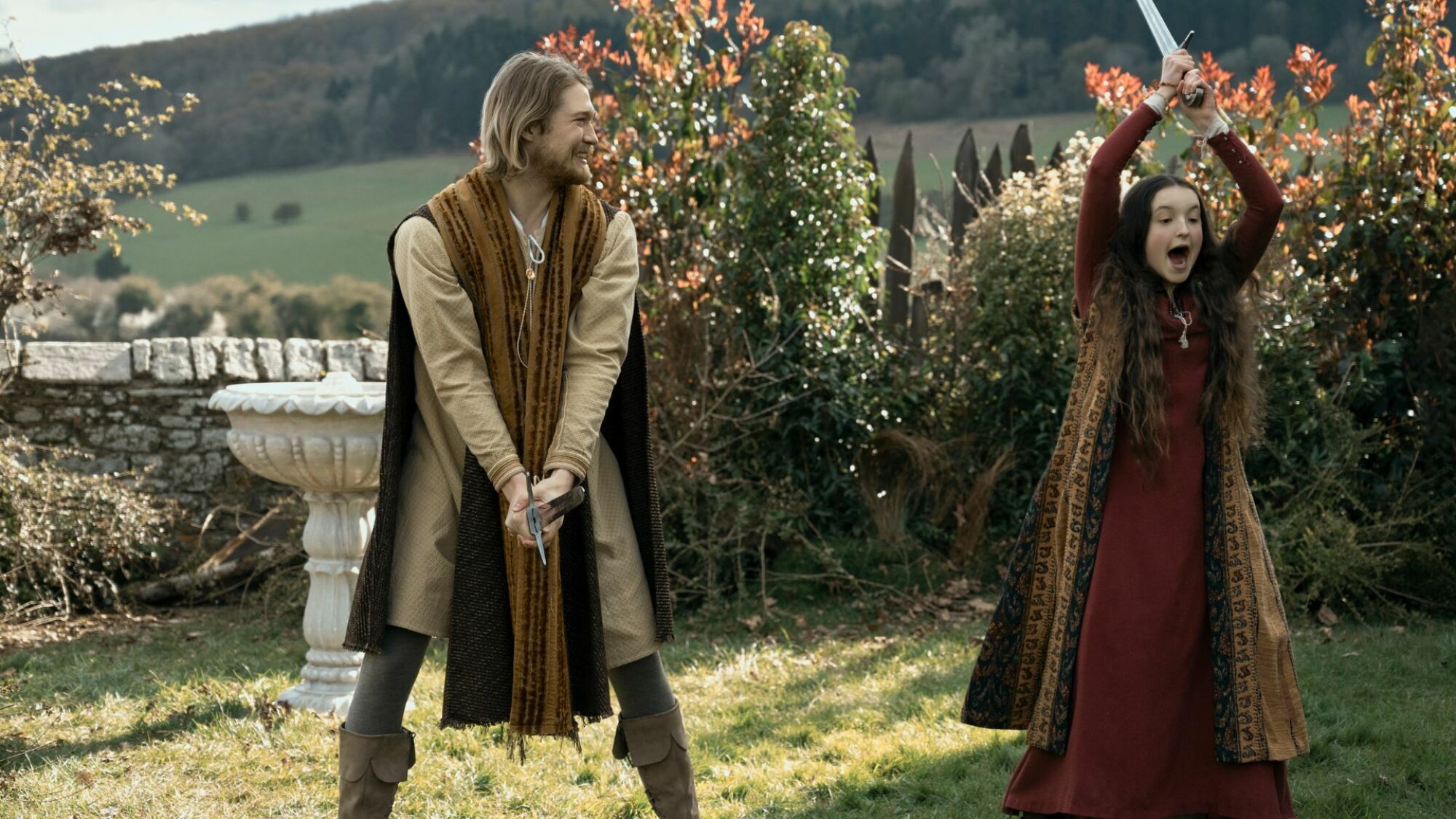 Bella Ramsey and Joe Alwyn play with swords in "Catherine Called Birdy."