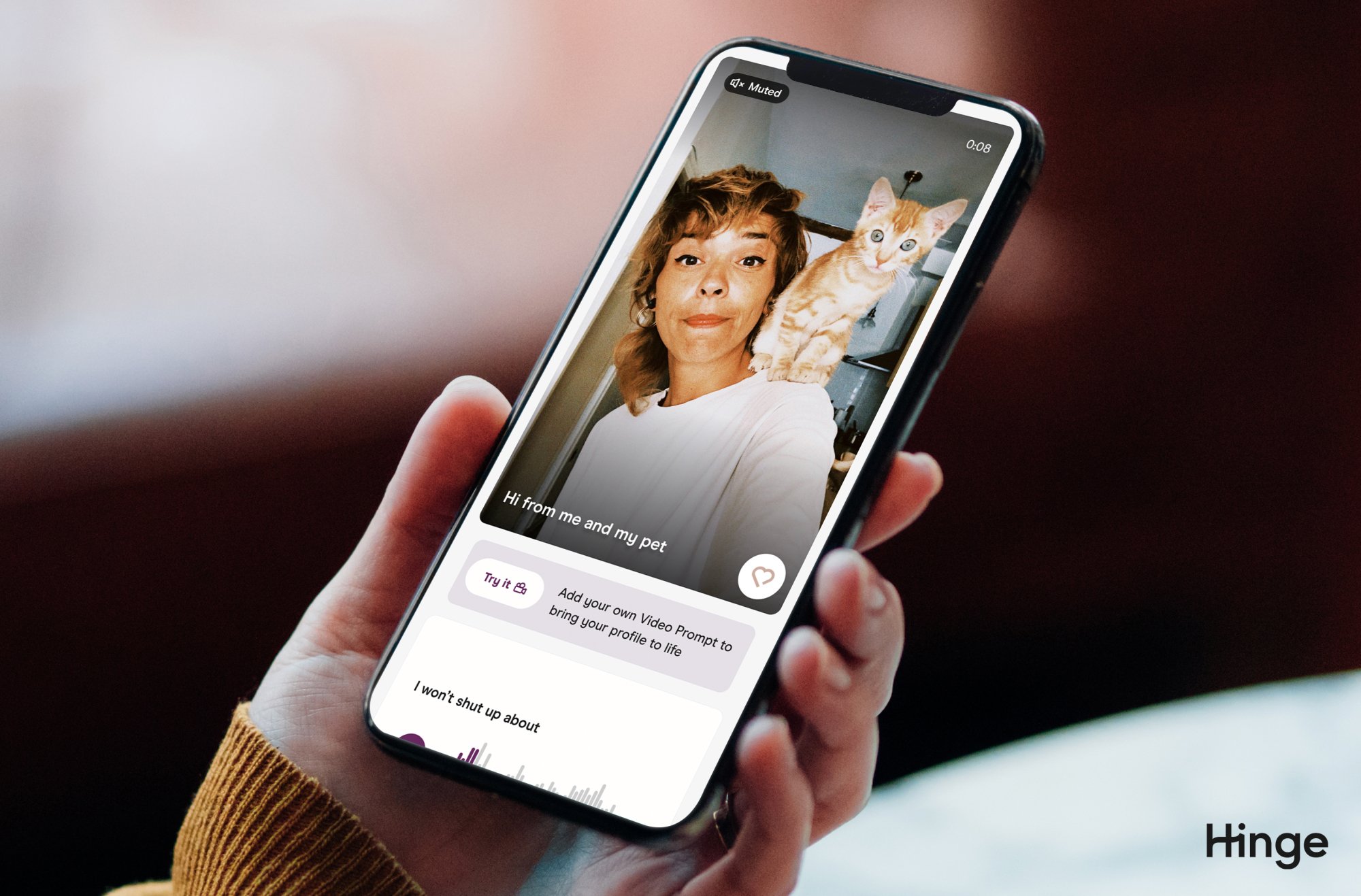 A hand holding a phone with Hinge app opened, a profile shows the new video prompt feature.