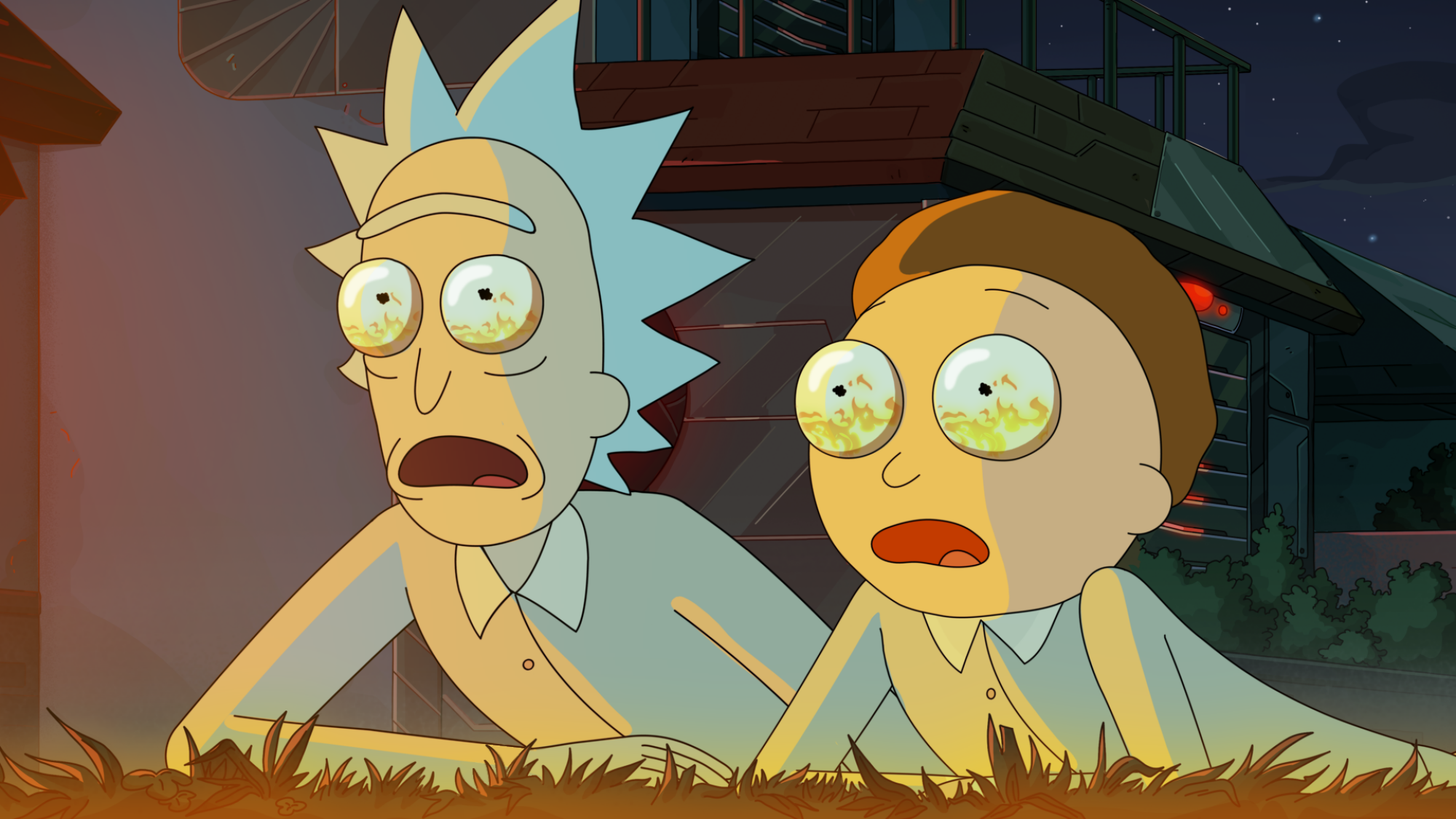 Rick and Morty lie on the ground, looking at fire.