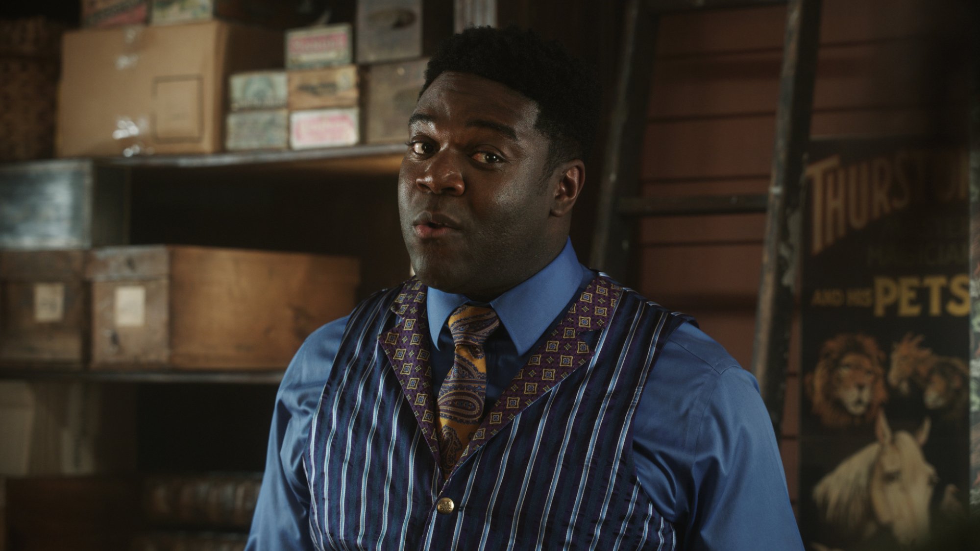 A man in a vest stands in a magic shop.