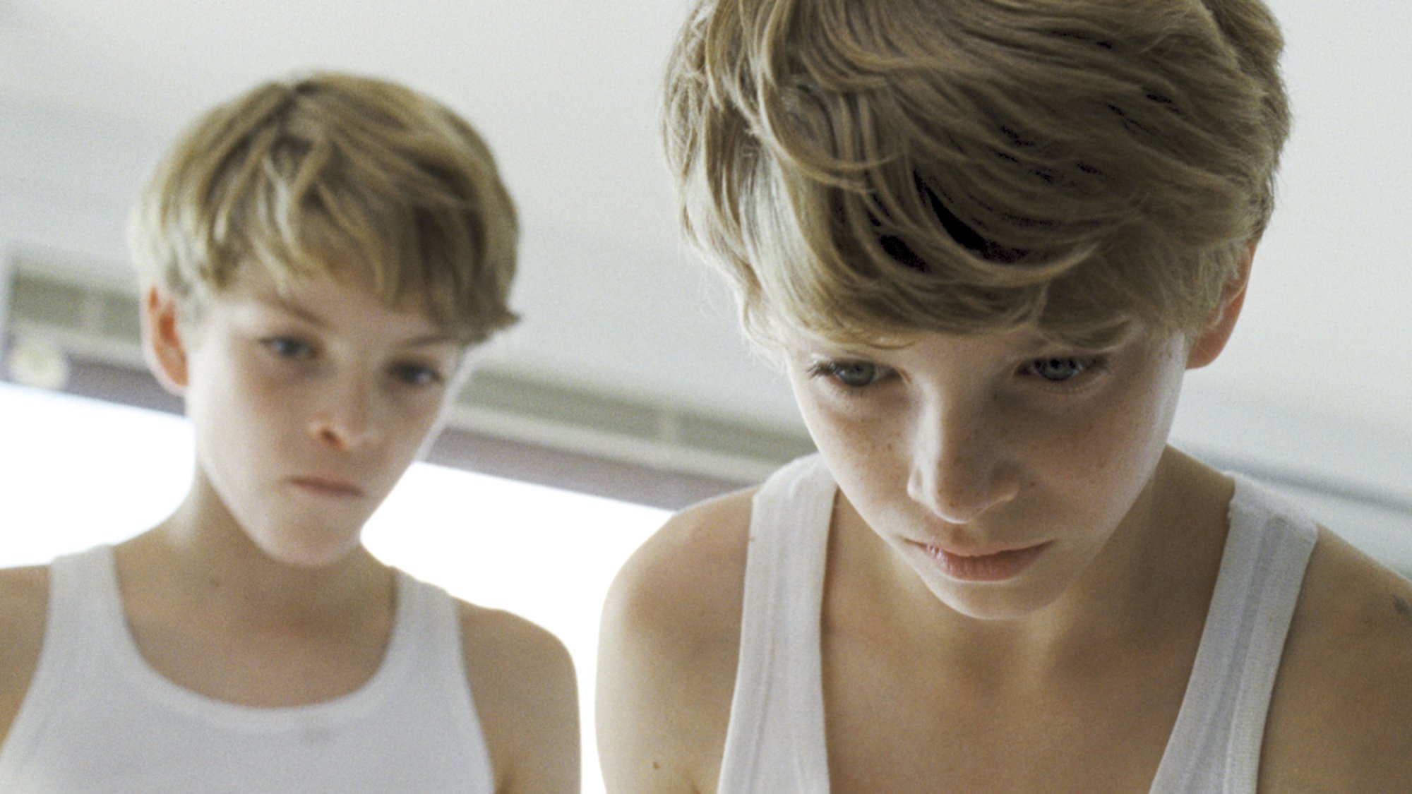 Twin boys stare down at the camera.