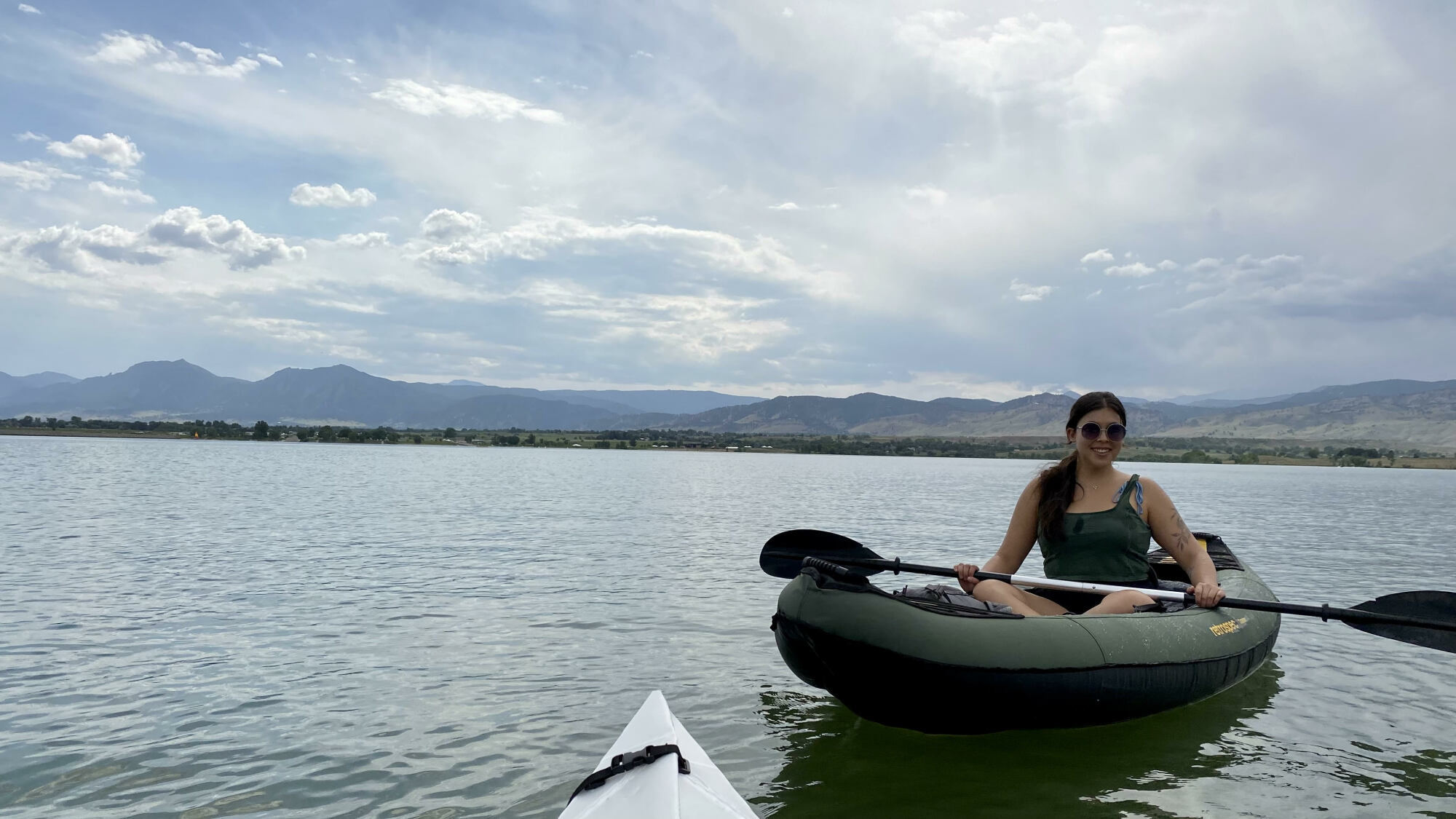 Person smiling while sitting in a green kayak