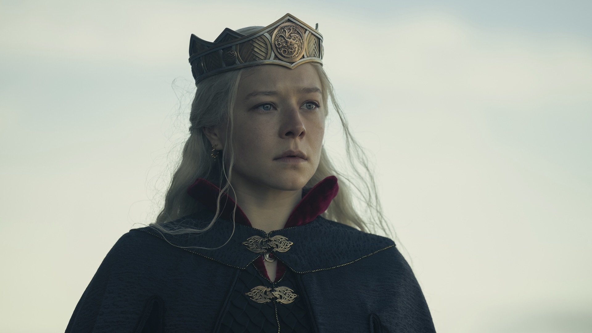 A woman with silver blonde hair in a crown and a black cloak.