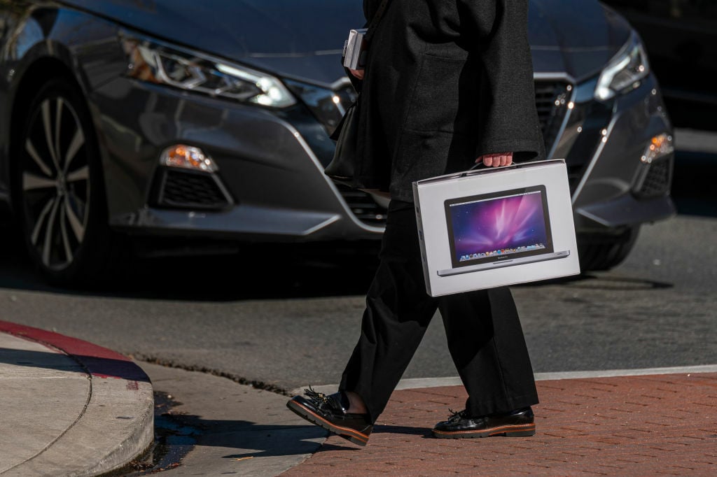 Man carrying a MacBook Pro in its product box