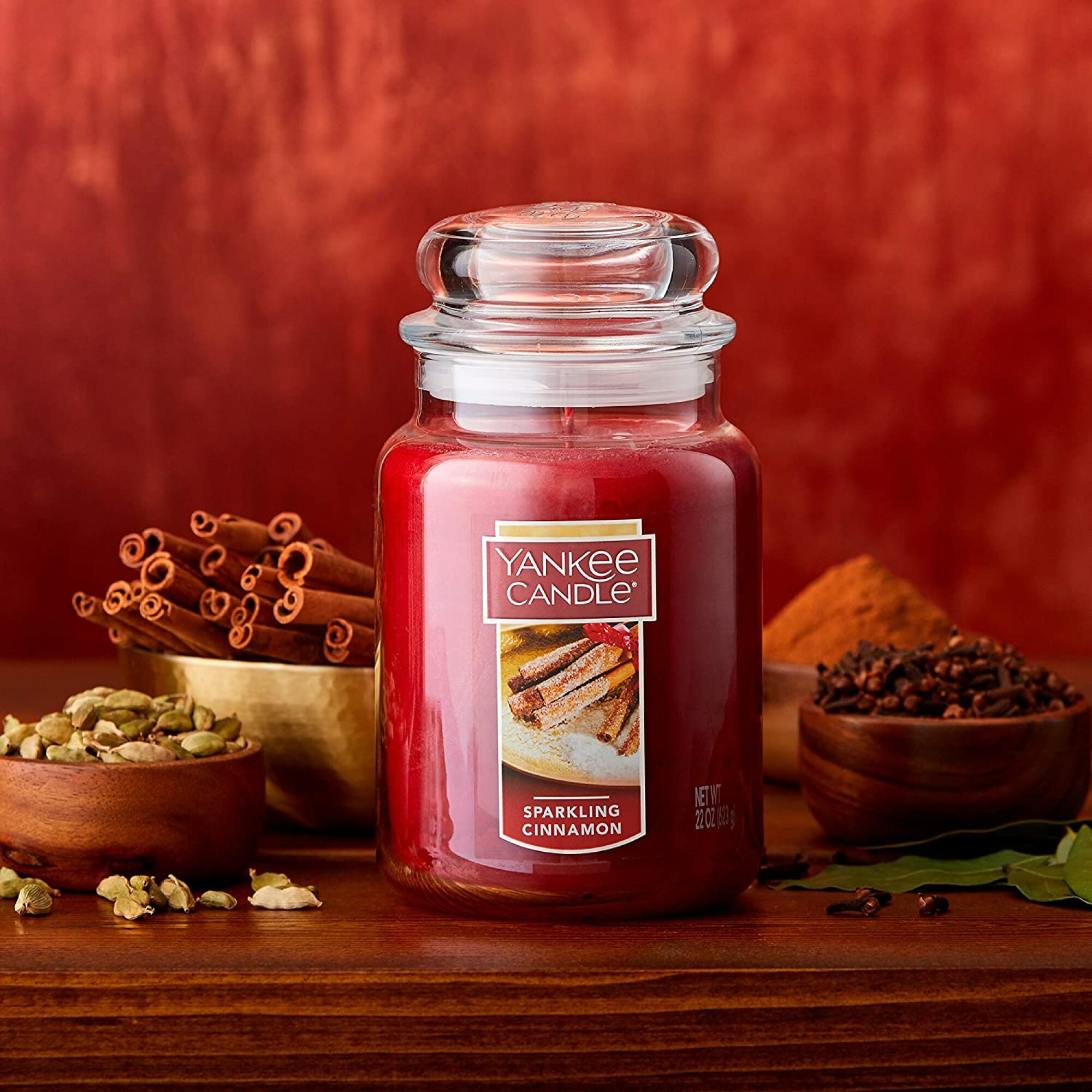 Yankee Candle Large Jar Candle (22 ounces), Sparkling Cinnamon on a red background.