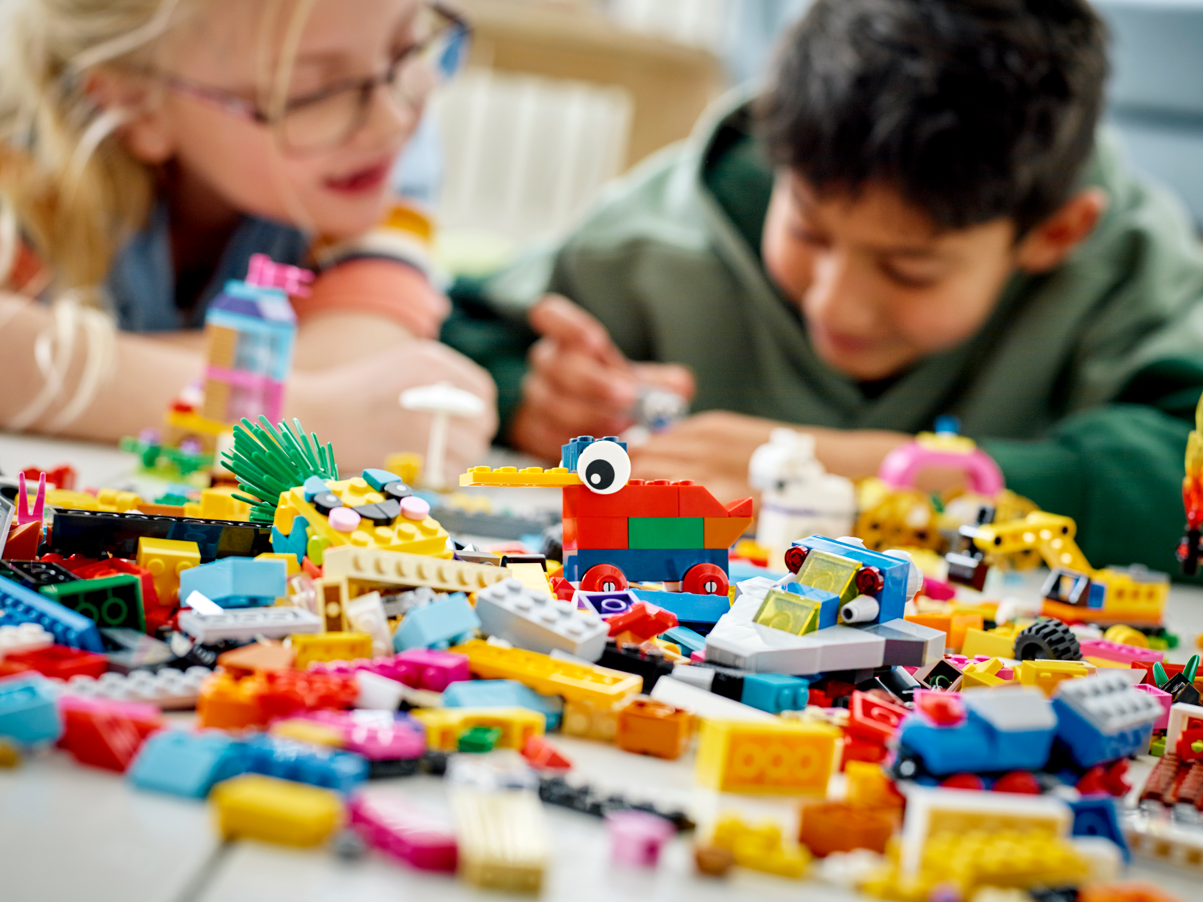 Pile of LEGOs with kids in background