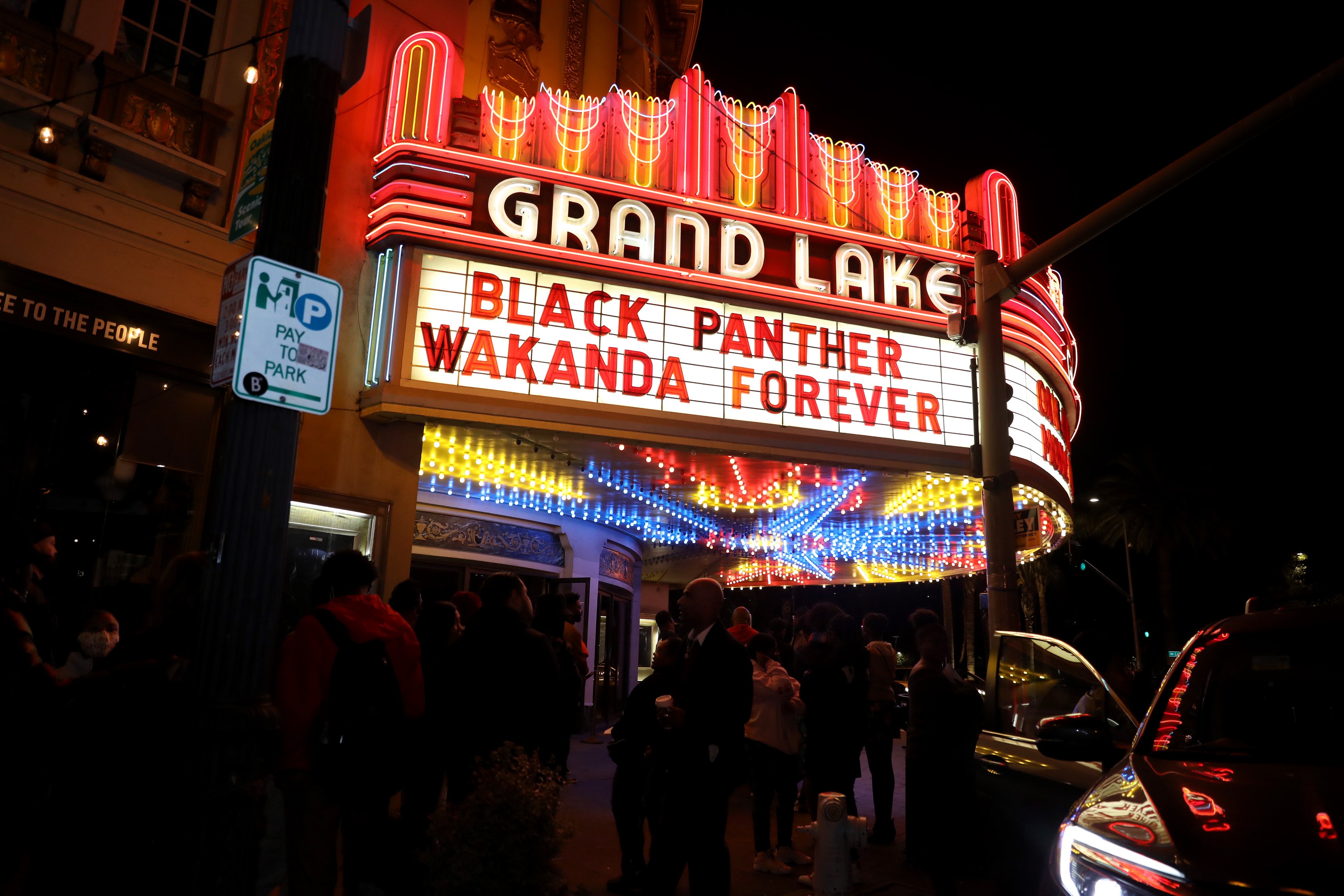 A glowing theater marquee sign reads, 