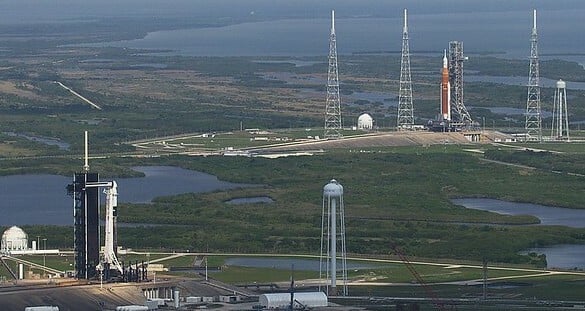 NASA's SLS and a SpaceX Falcon 9 rocket preparing to takeoff at Kennedy Space Center