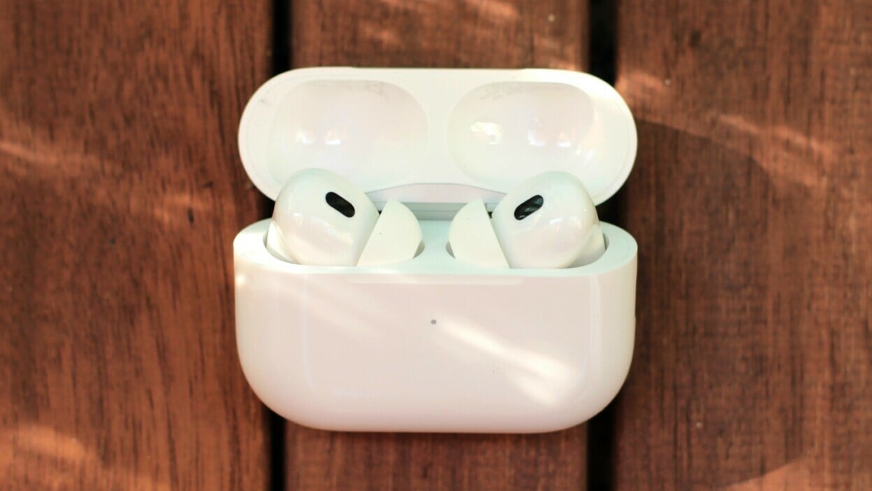 AirPods Pro (2nd generation) in wireless charging case against wood table background