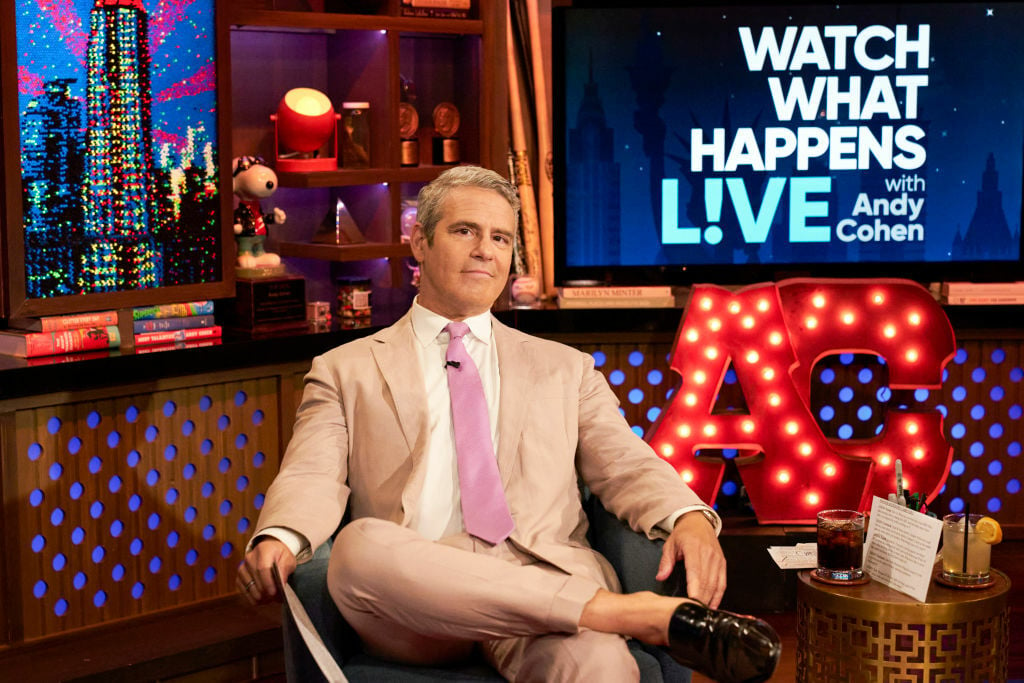 Andy Cohen seated posing for the camera on Watch What Happens Live