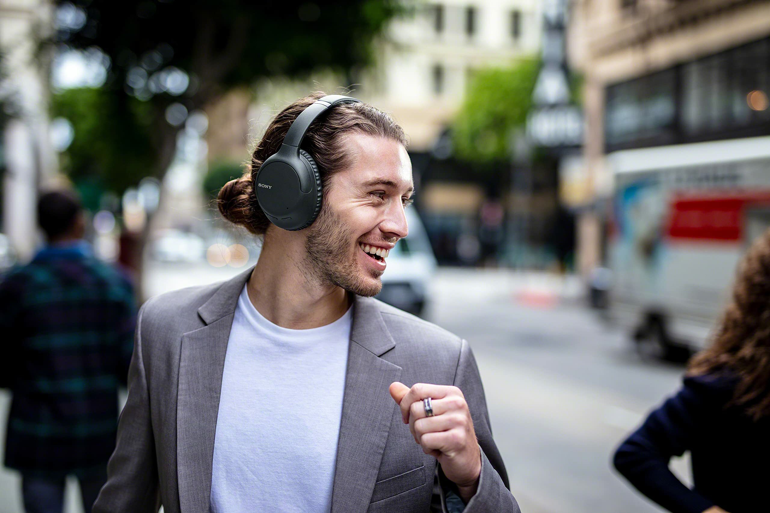 Man smiling in urban environment with Sony headphones