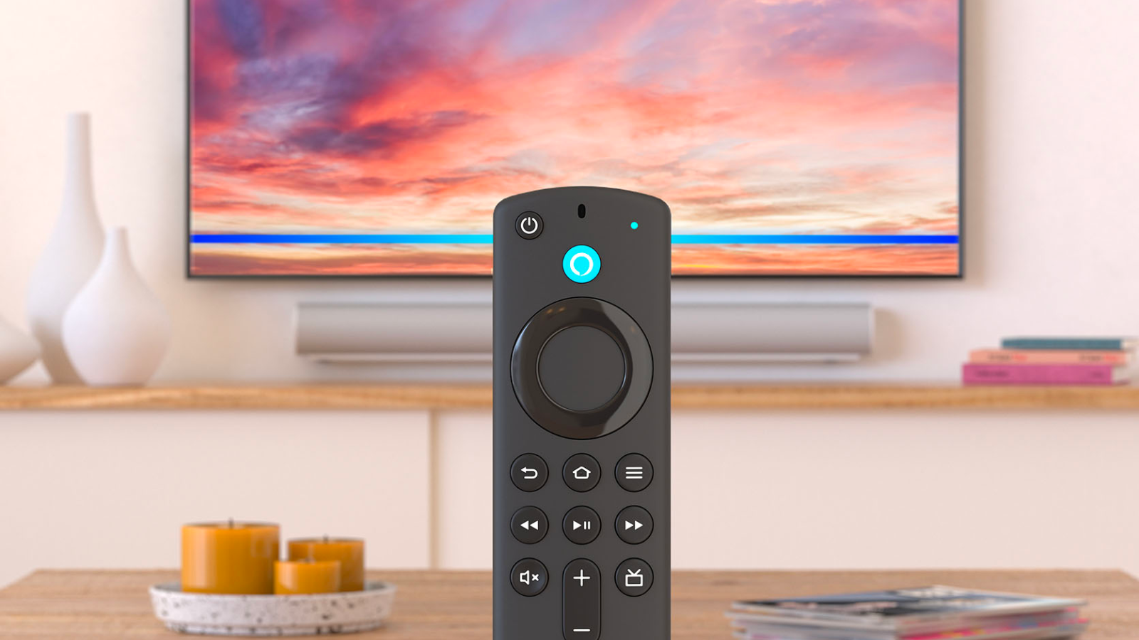 an alexa voice remote in front of a wooden coffee table and a tv displaying a sunset