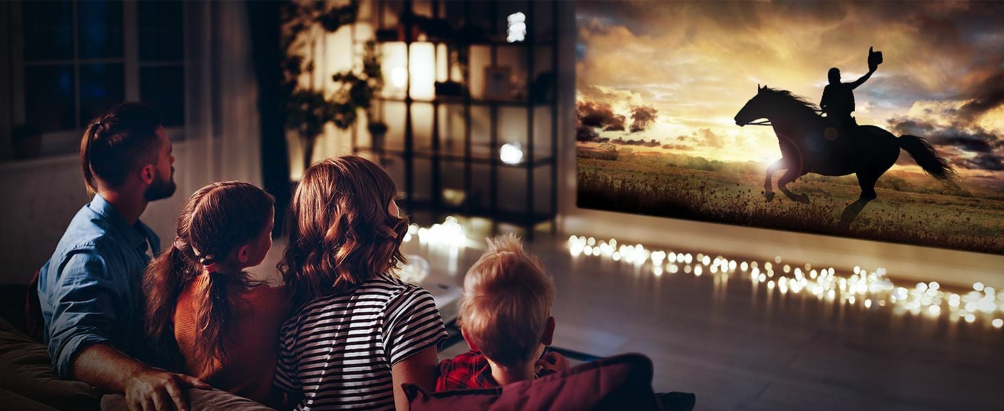 A family is watching a movie on a wall thanks to a projector