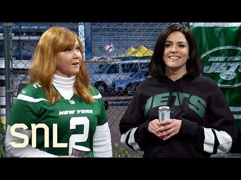 Amy Schumer and Cecily Strong wearing green Jets home jersey and Black Jets hoodie respectively