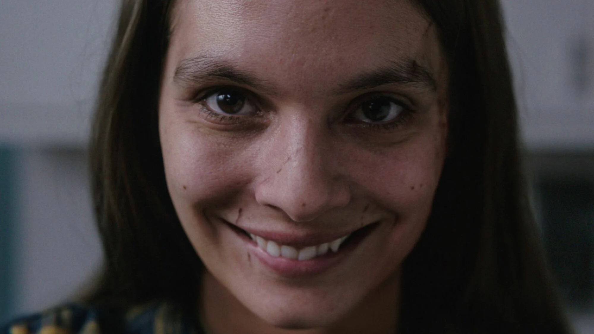 A creepily smiling girl in close-up.