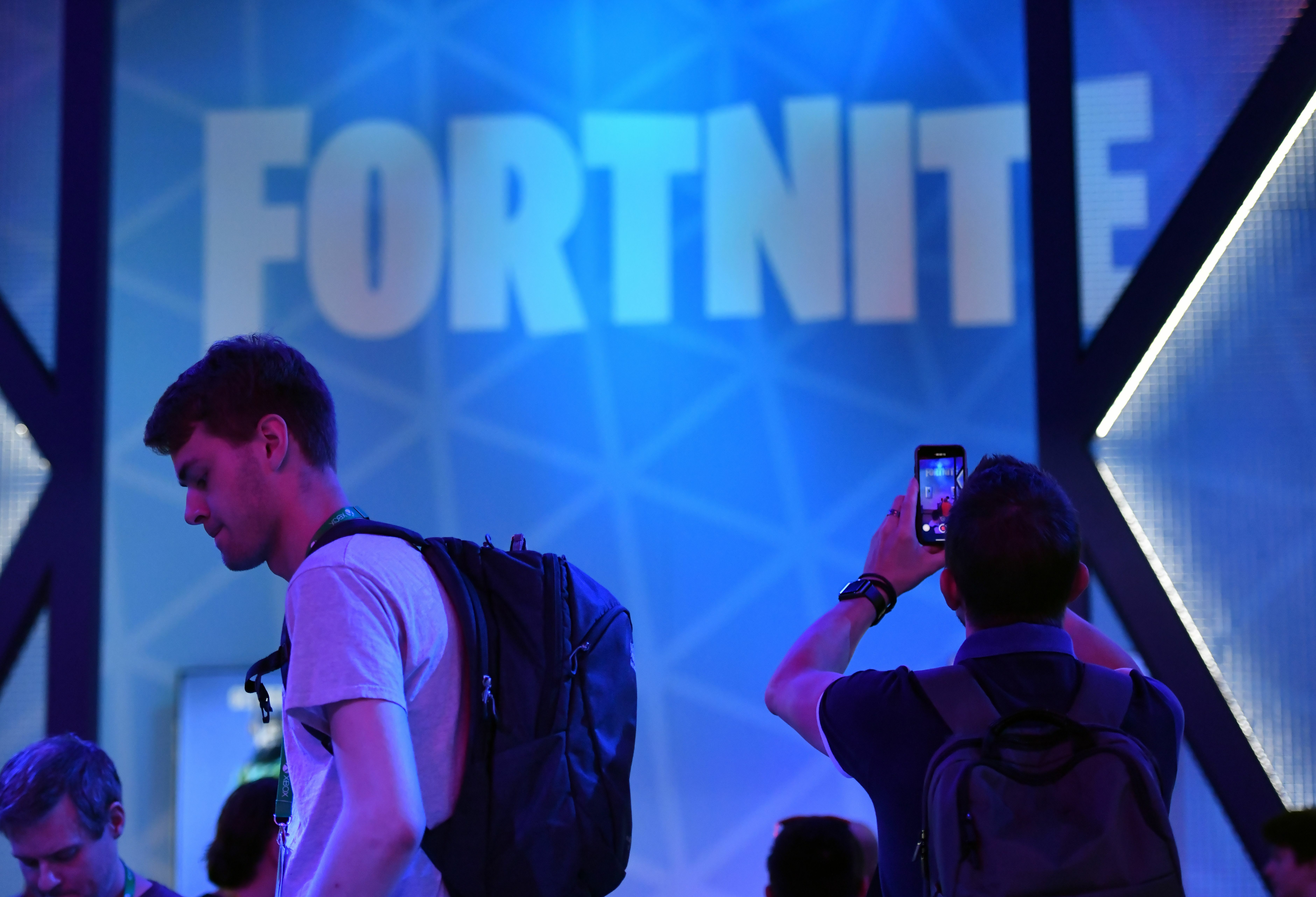 People in front of the Fortnite logo