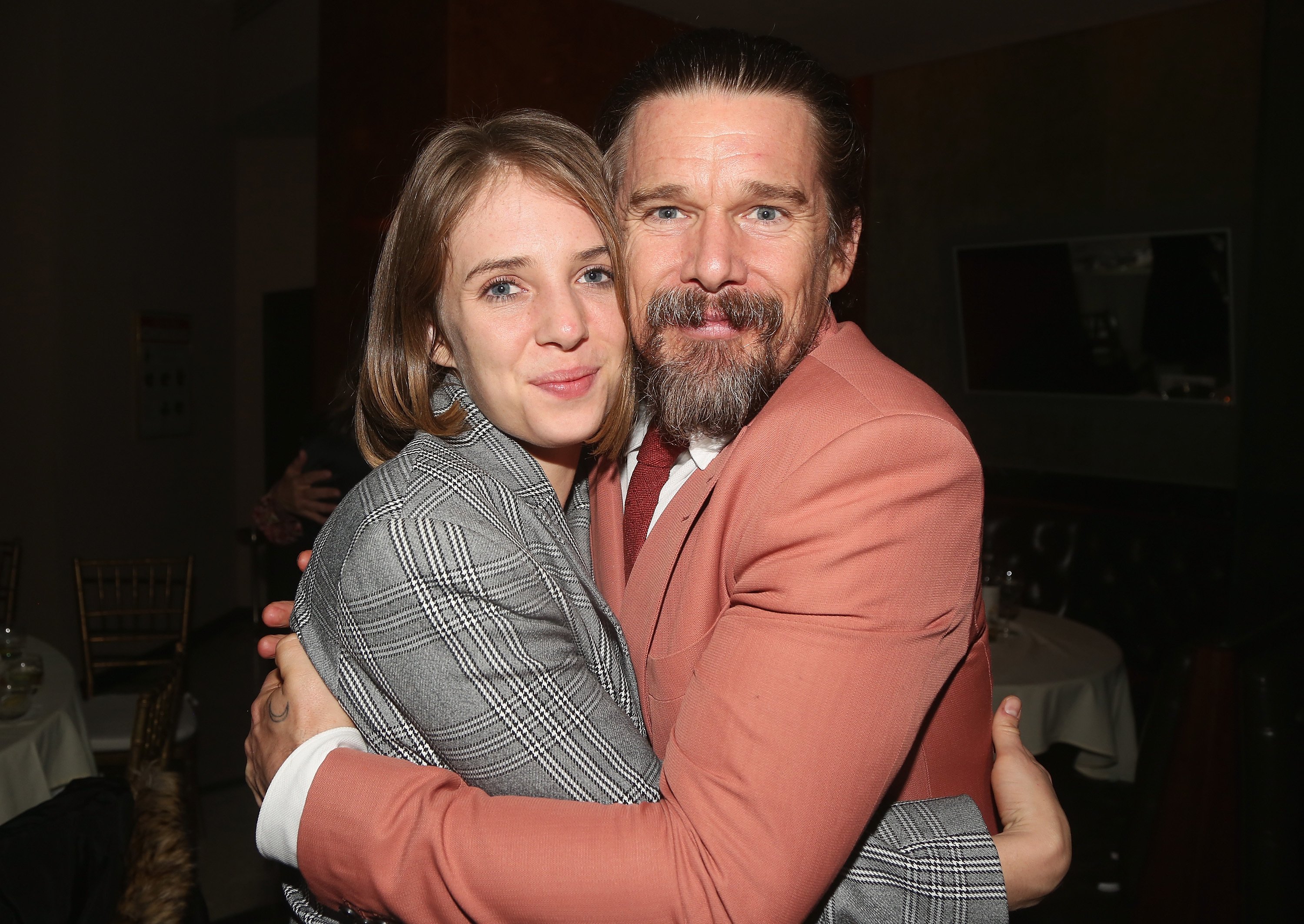 Maya Hawke and Ethan Hawke hugging on the red carpet.