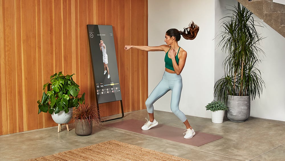 Woman doing a boxing workout in front of a smart mirror