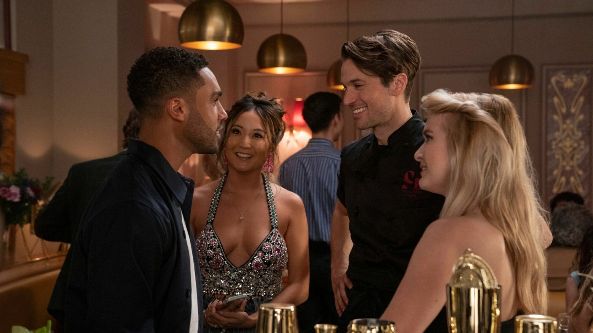 A group of friends chatting happily at a restaurant bar.