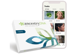 AncestryDNA kit in front of a phone against a white background
