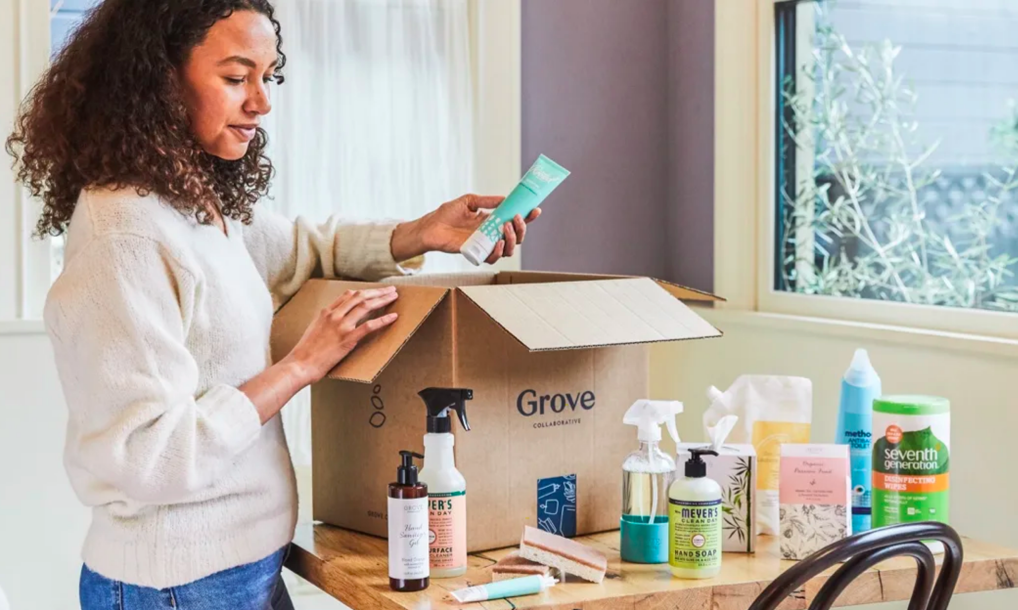 a woman unpacking a box of cleaning supplies