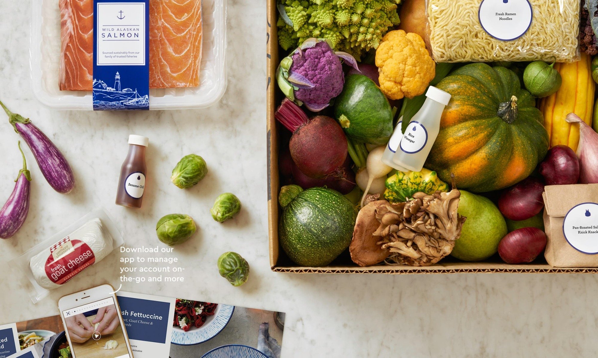 fresh produce and raw salmon sit beside recipe instructions