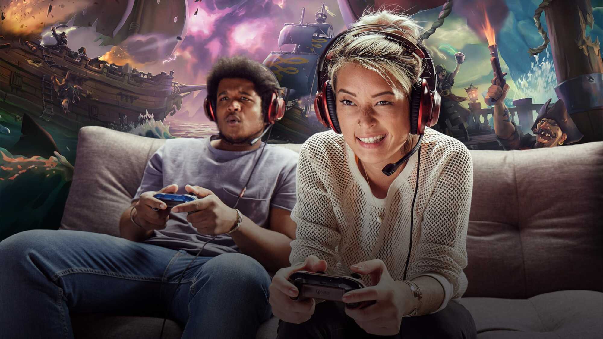 two people playing video games on a couch