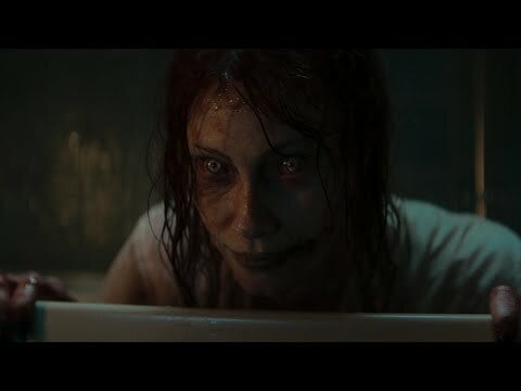 A bloody, smiling woman in a bathtub.