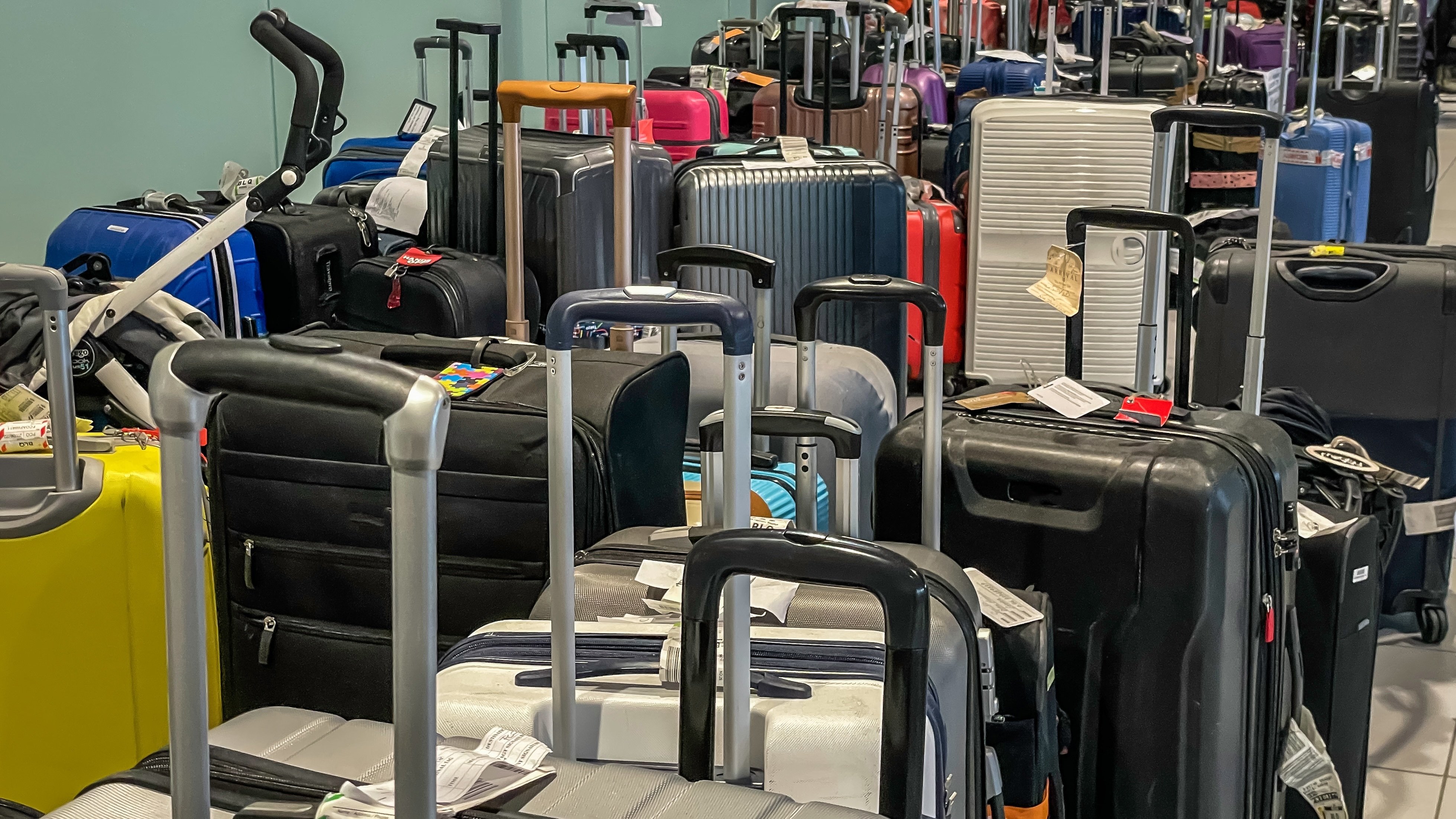 Several bags of luggage sit in an airport area. 