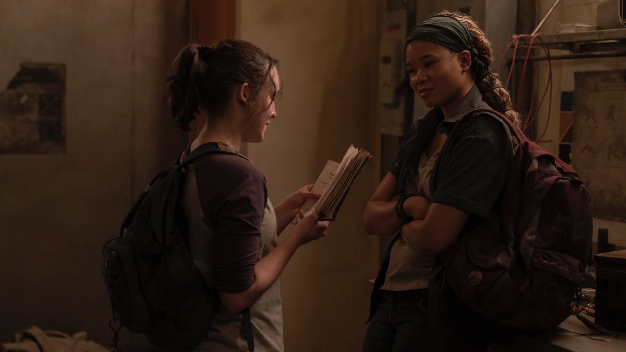 Two teenage girls hanging out in an abandoned mall; one is reading a book to the other.