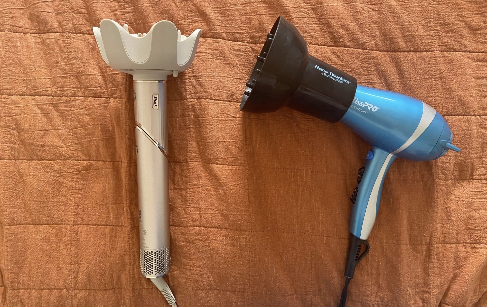 shark flexstyle in wand mode next to a blue babylisspro hair dryer