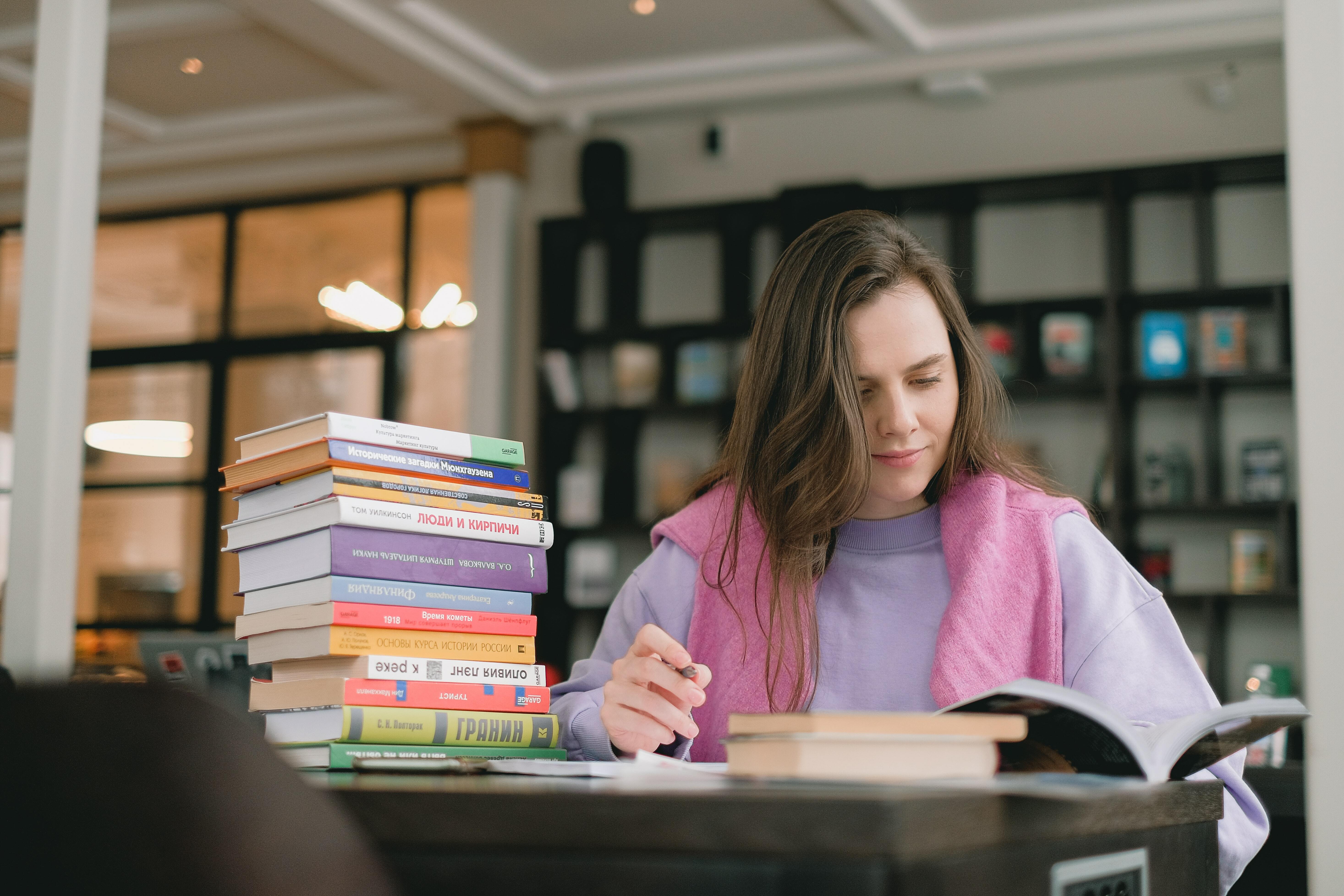 Student at desk with pile of books