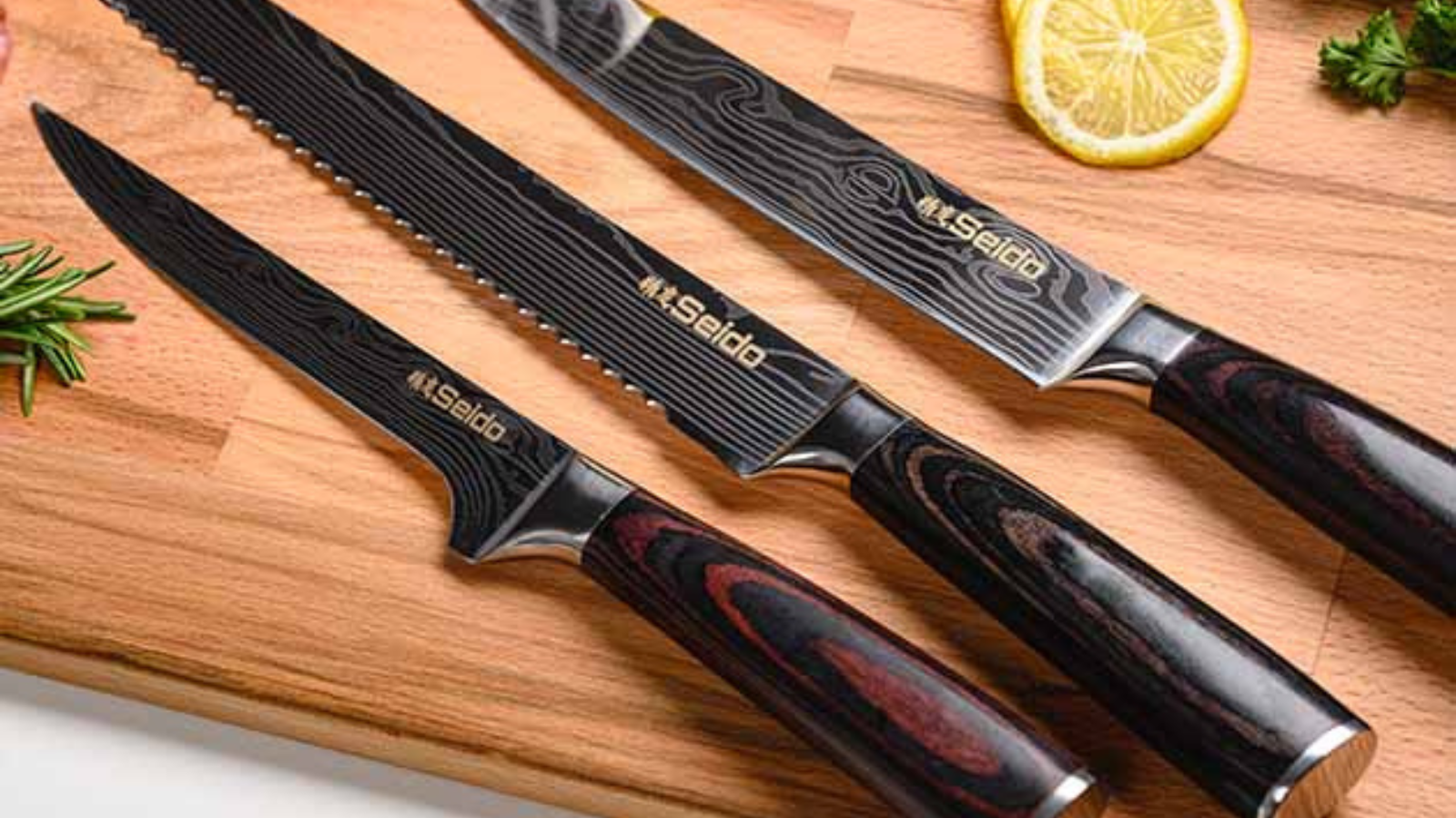 three seido knives on cutting board next to herbs and lemon